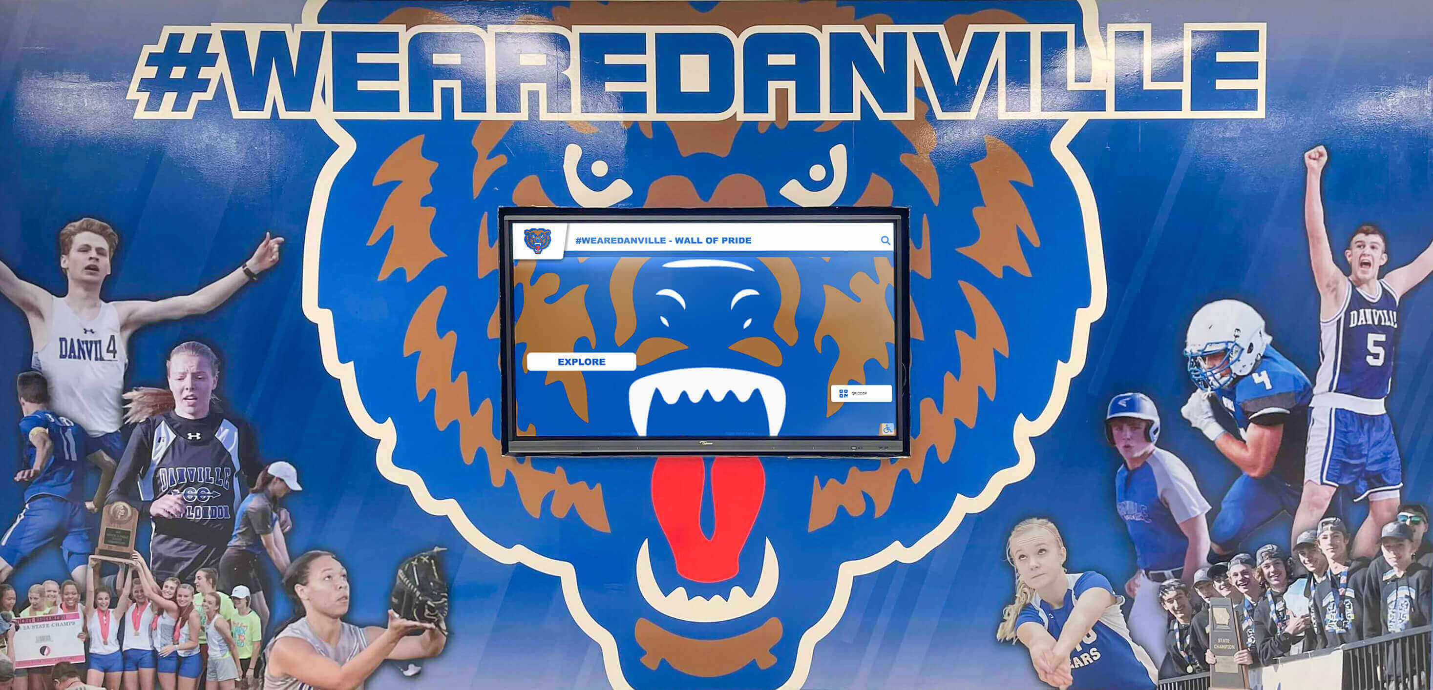 School athletic display integrated with mascot mural Athletic hallway with digital display