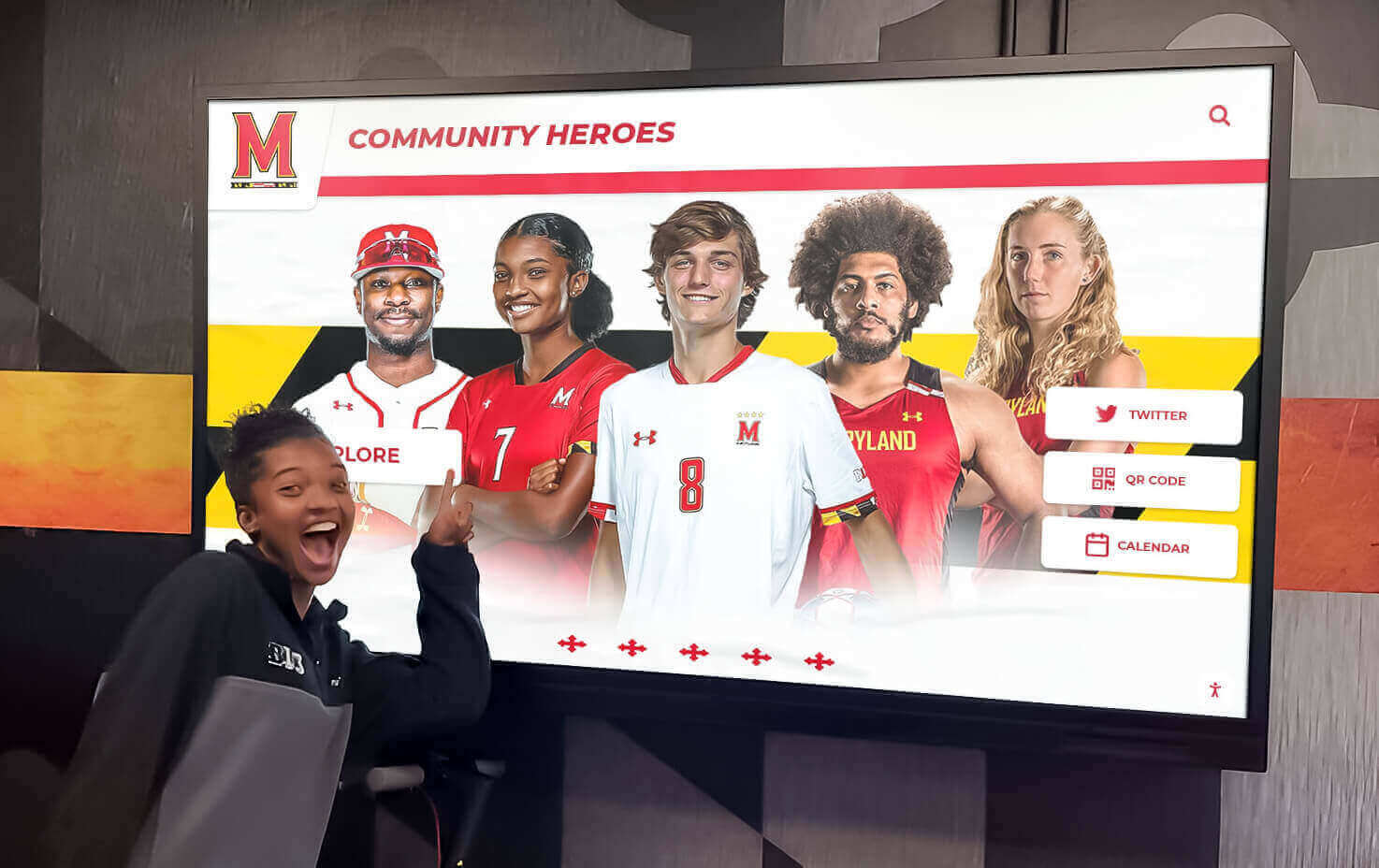 Students exploring college commitment recognition on interactive display Digital recognition display showing student achievements